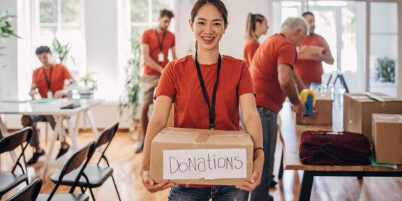 Girl in the foreground holding a box containing donations.